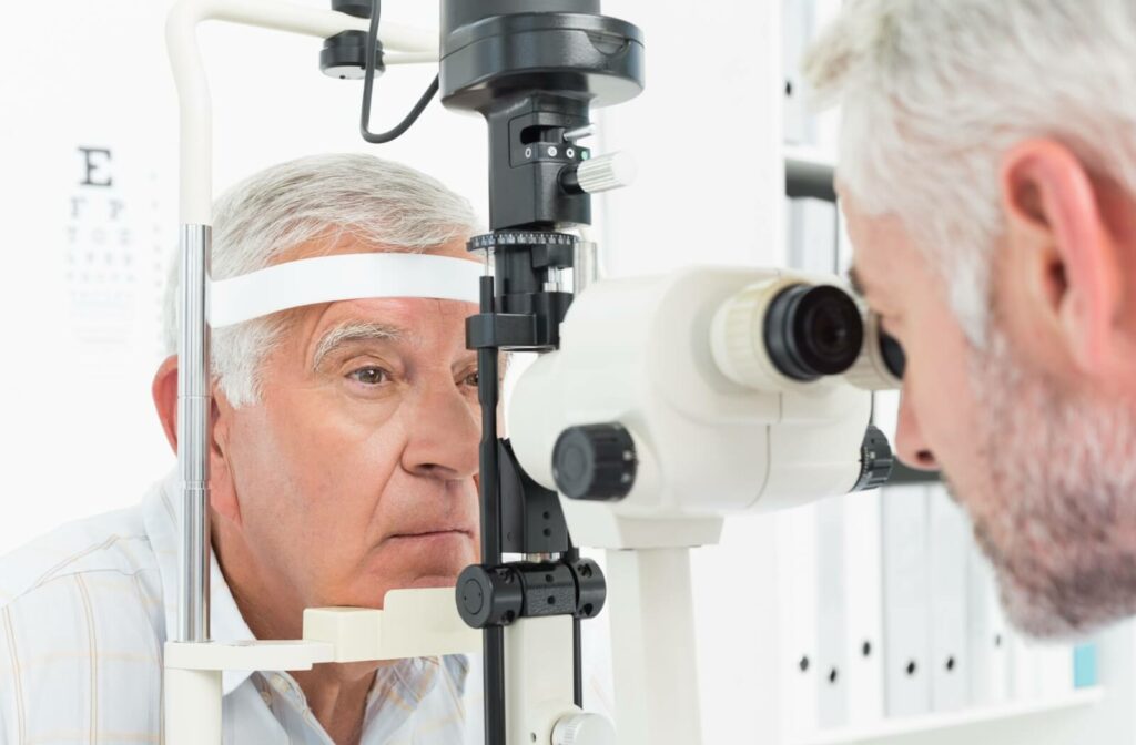 An older man undergoes a detailed eye exam with a slit lamp at an optometrist's office to assess his optic nerve health