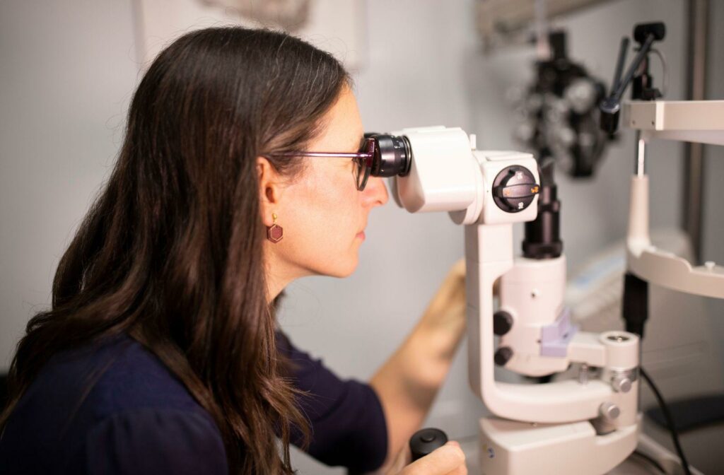 An optometrist examines with a slit lamp in an exam room
